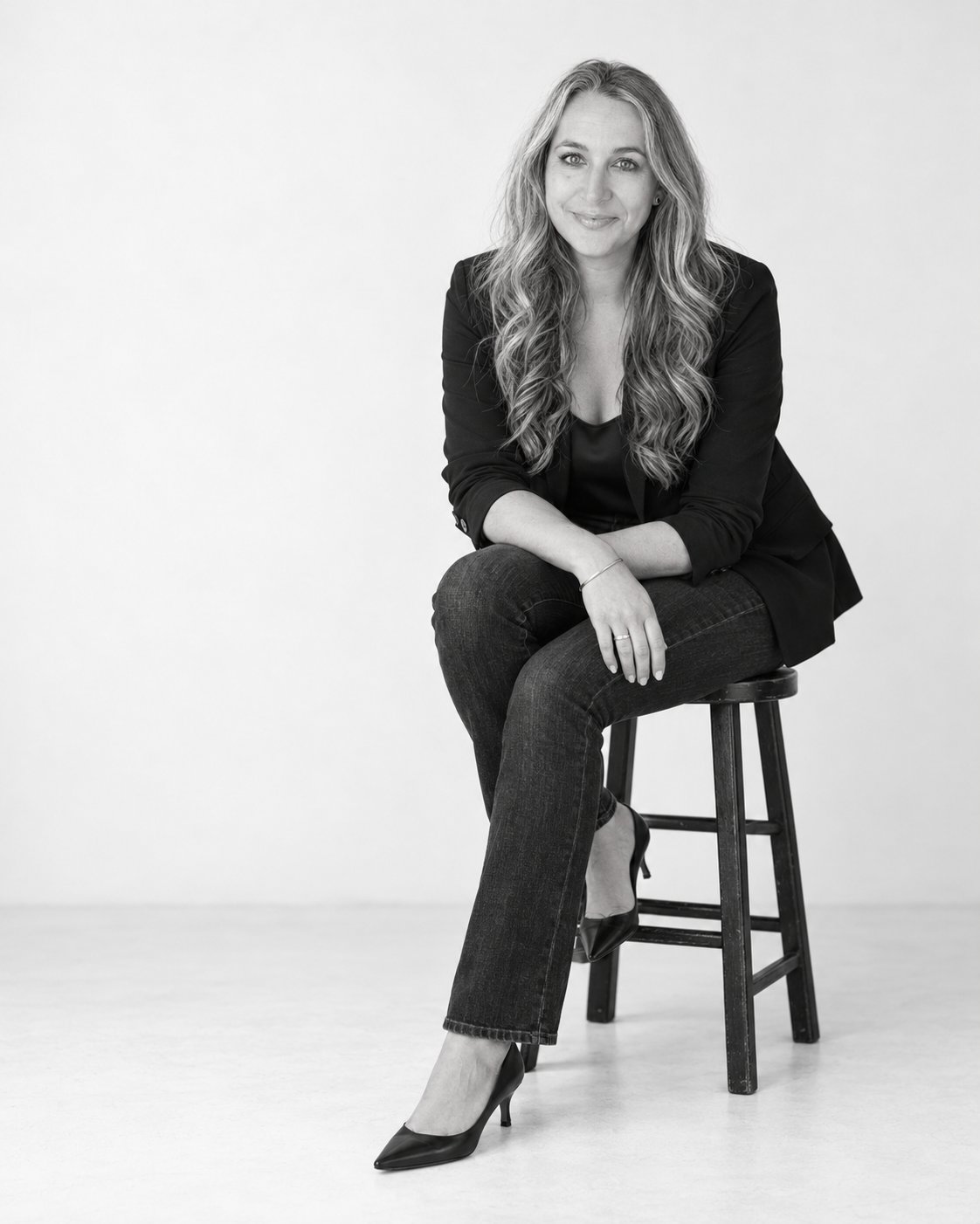 Amy Oughton seated in a black-and-white studio portrait.