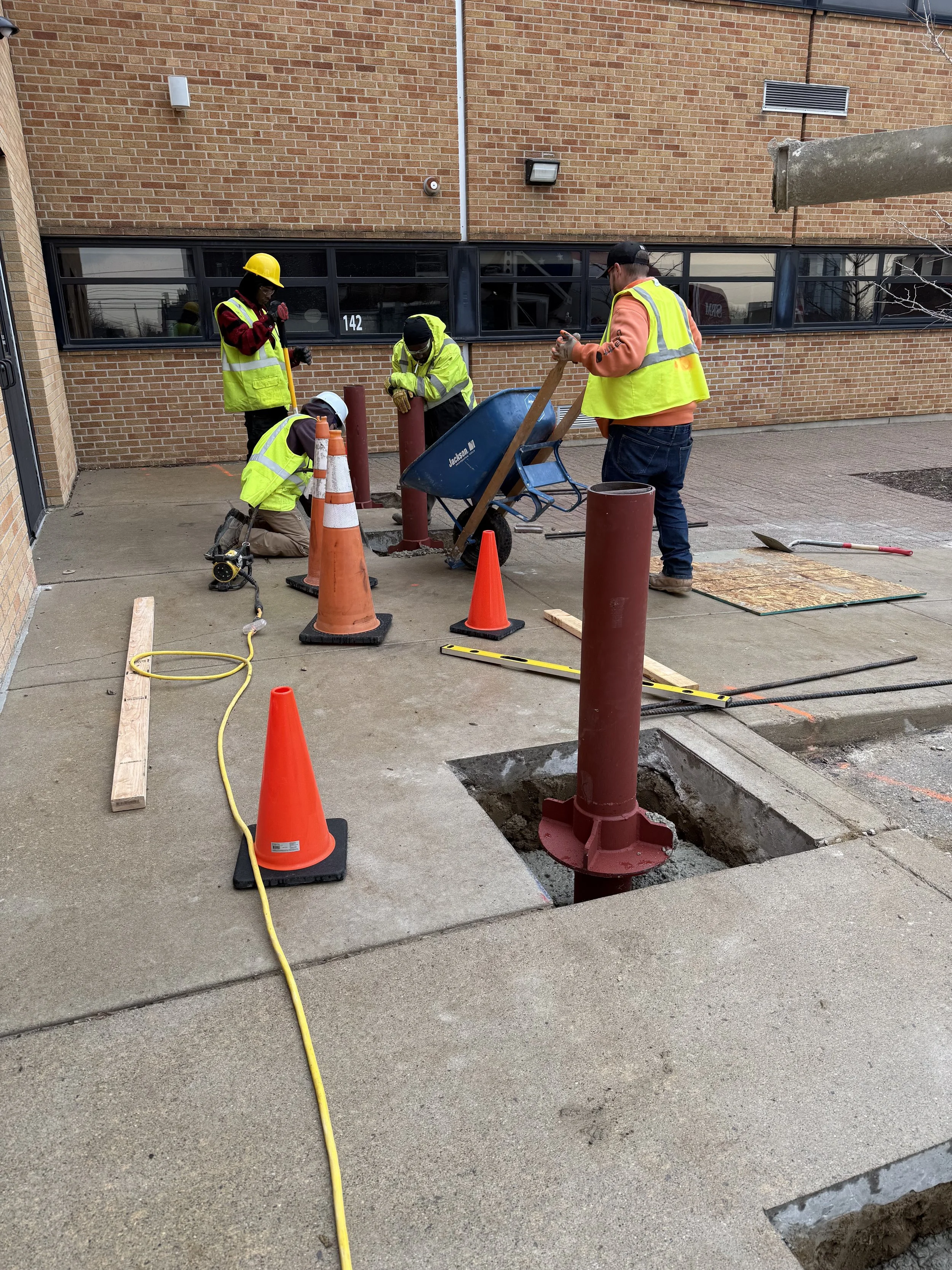 Trident Industrial Systems crew installing ASTM F2656 crash-rated security bollards at St. Mary Catholic School, Mount Clemens Michigan, during NSGP-funded nonprofit security installation