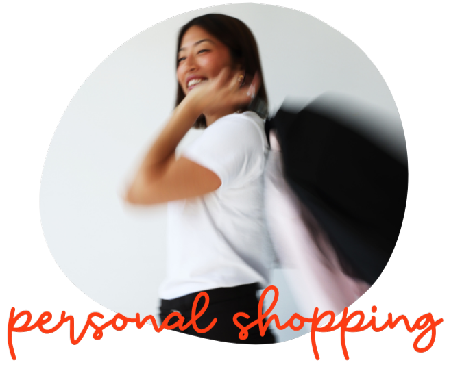 A woman smiling and carrying clothing on hangers, with the words "personal shopping" written in red at the bottom.