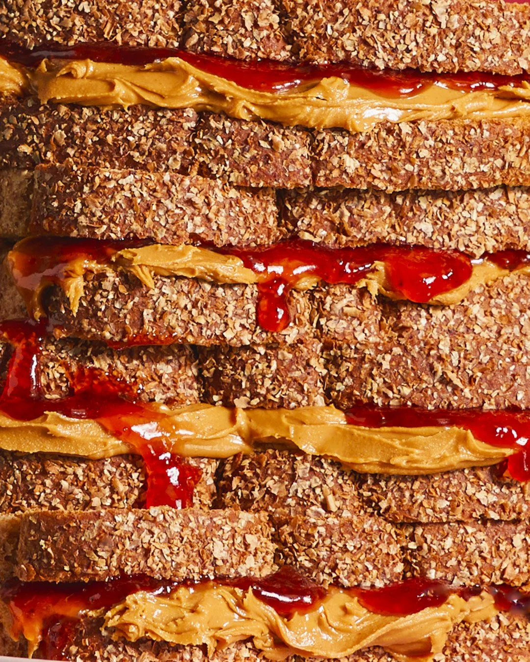 Close-up of a stack of granola bars with peanut butter and jelly layers.