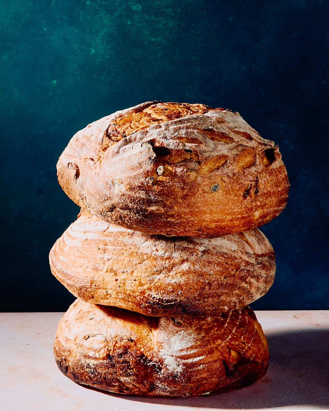 Stacked artisanal bread rolls dusted with flour