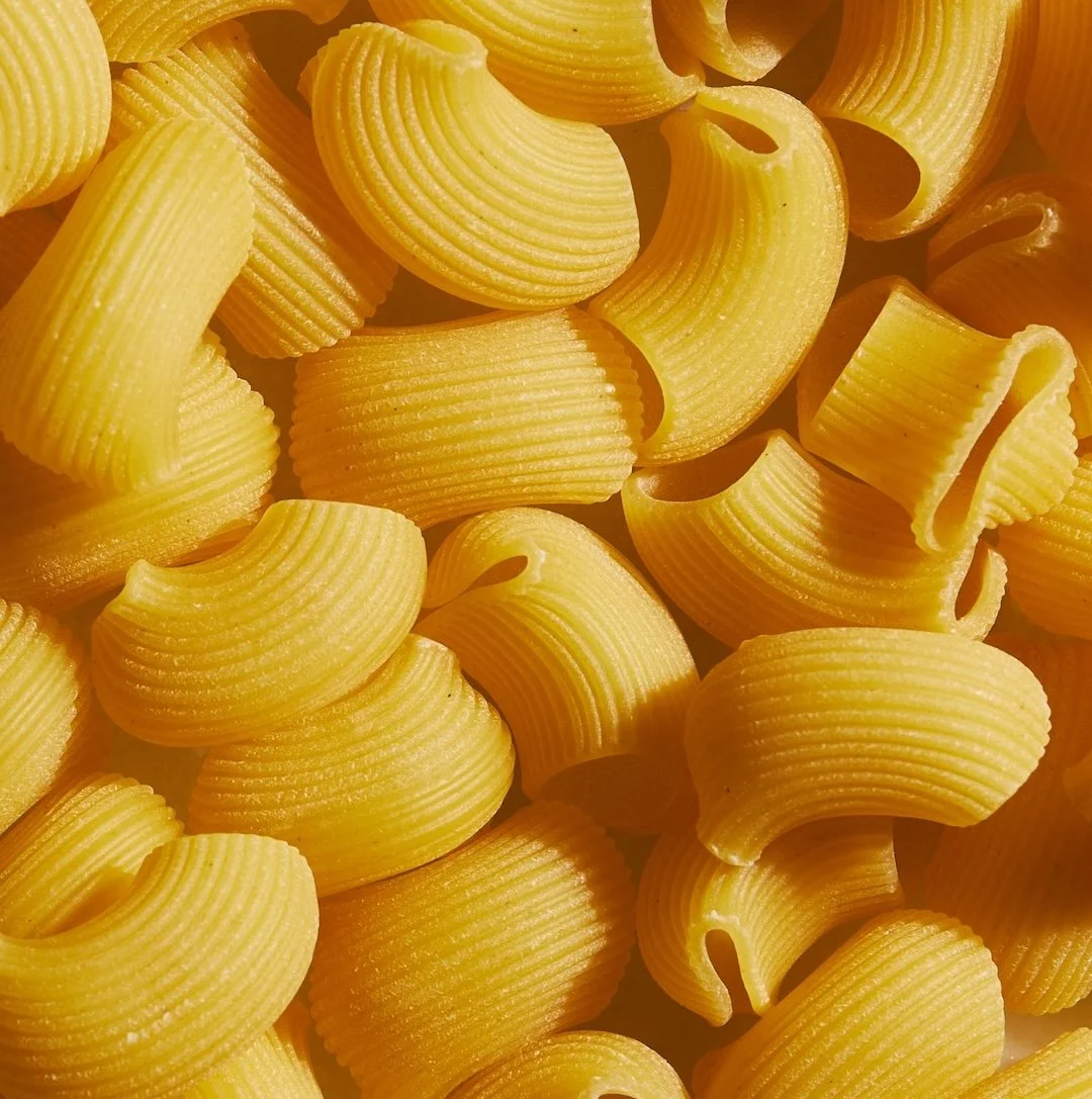Close-up of uncooked rigatoni pasta with ridges.