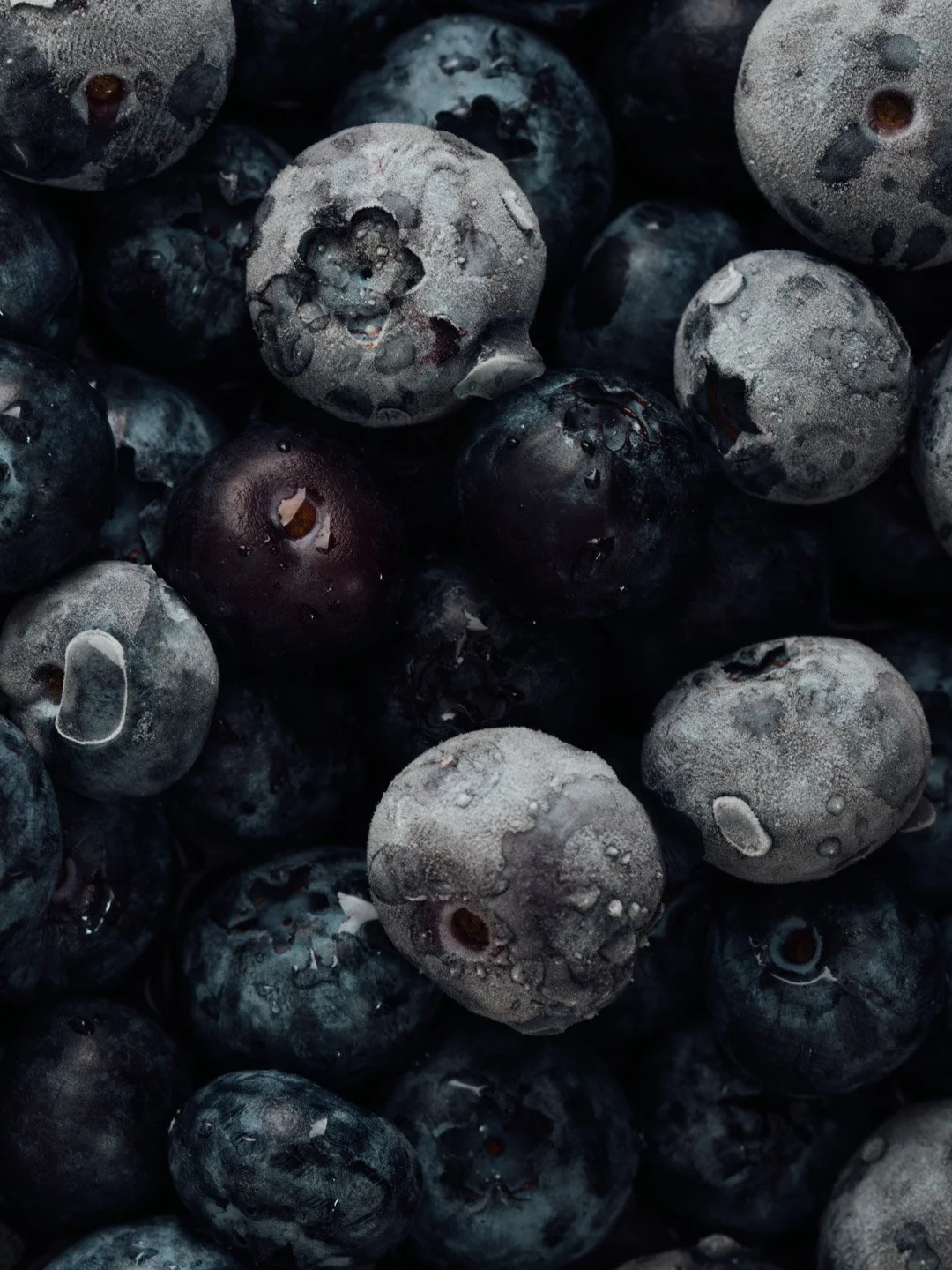 Close-up of frozen blueberries with ice crystals and water droplets.