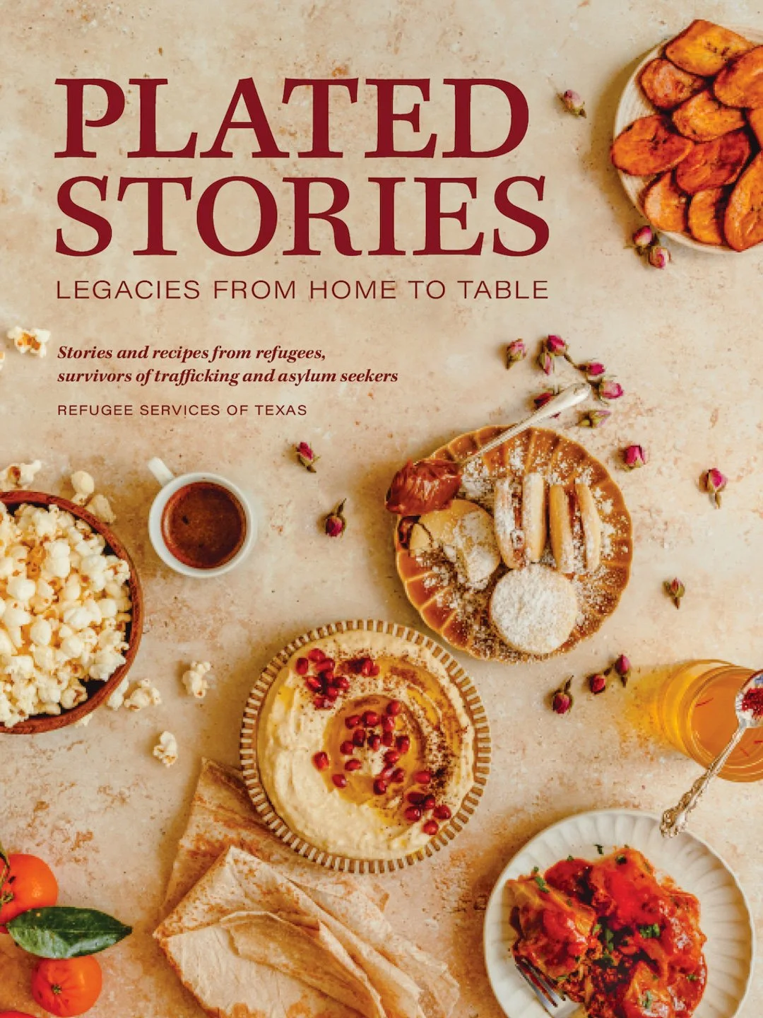 Book cover titled 'Plated Stories: Legacies from Home to Table' with images of food such as chicken wings, popcorn, honey, hummus with pomegranate seeds, tomato sauce, flatbread, and roasted potatoes on a table.