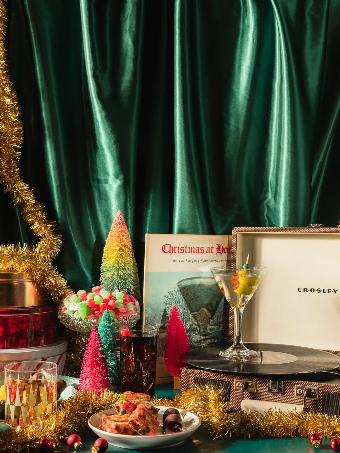 Festive Christmas-themed table with candy, a vinyl record player, books, and decorations.