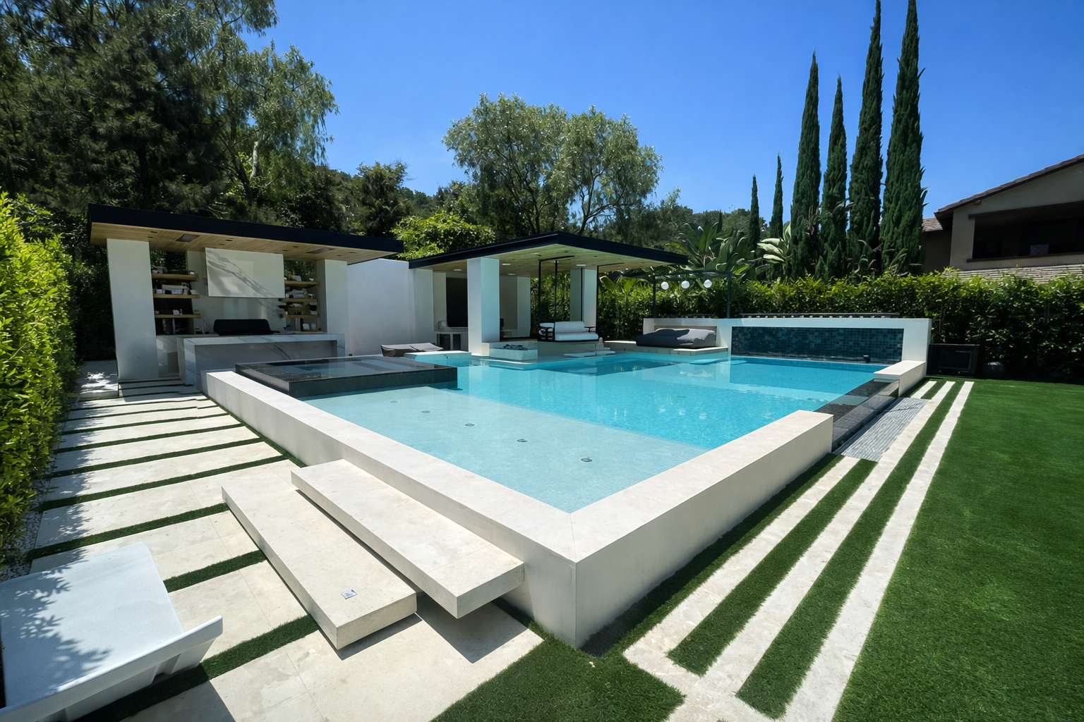 Modern backyard with a rectangular swimming pool, lounge chairs, and shaded seating area, surrounded by greenery and tall trees.