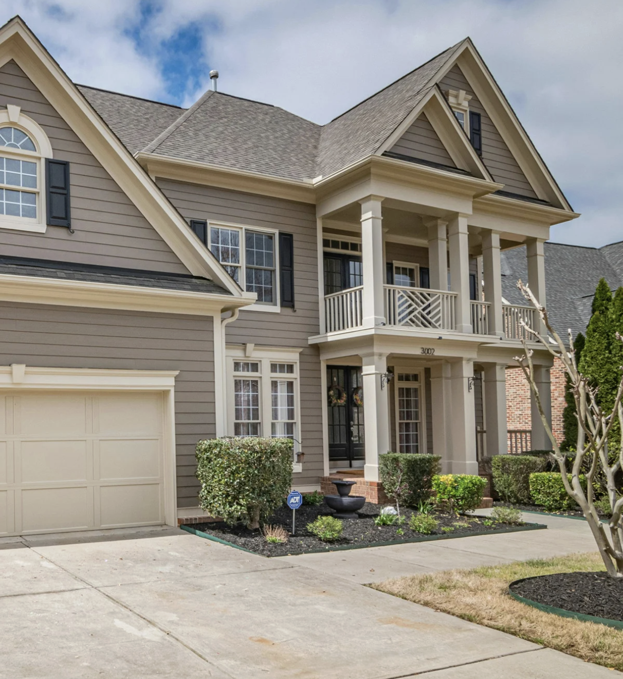 Modern two-story home with new siding and white-trim windows, showcasing clean exterior craftsmanship.