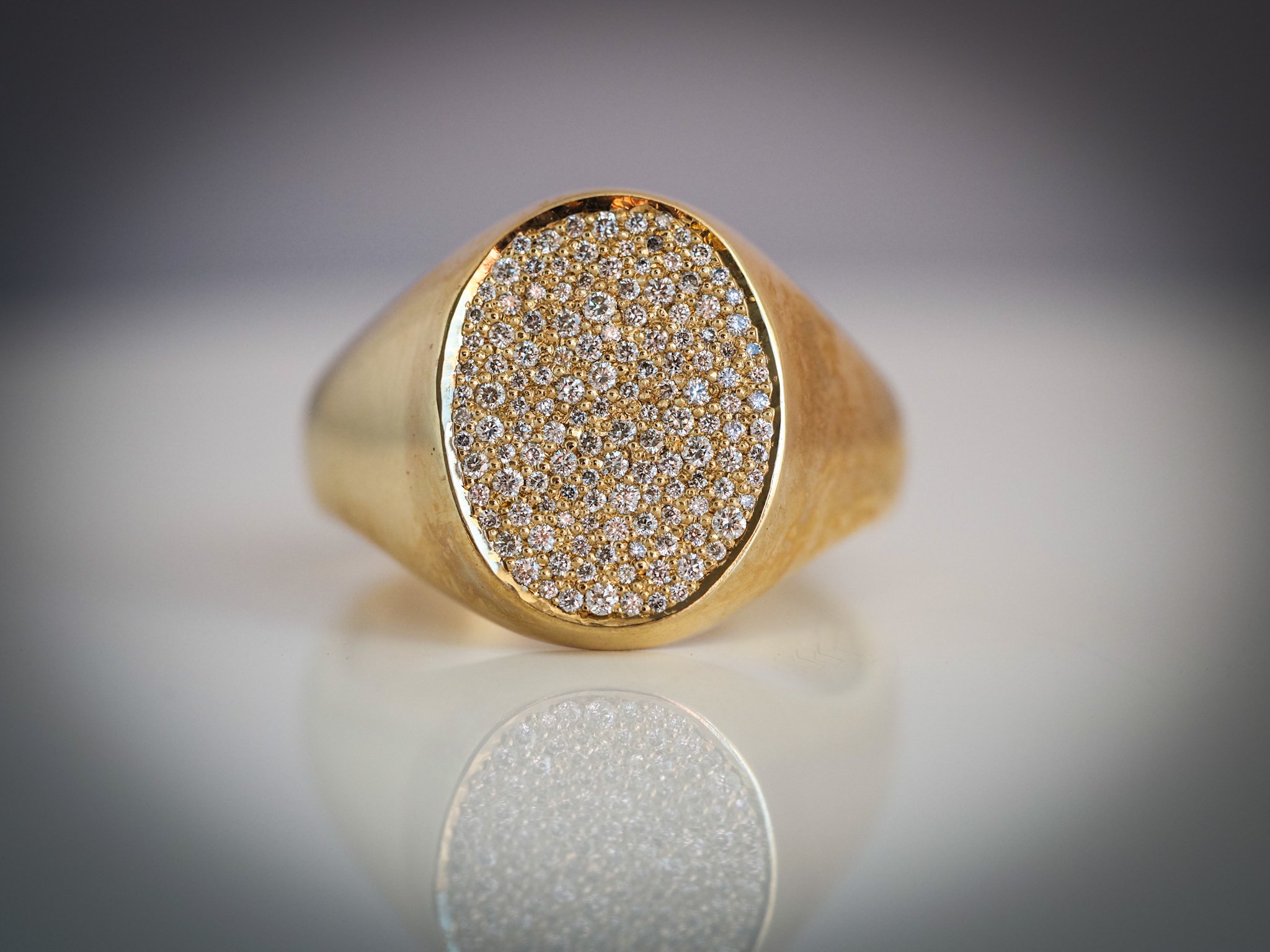 Gold ring with an oval face covered in small diamonds.