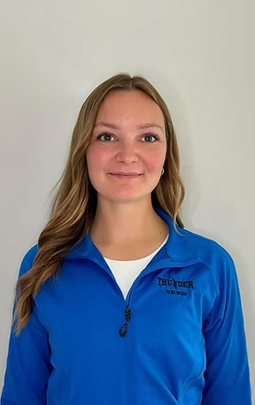 Woman smiling, wearing a blue sweater