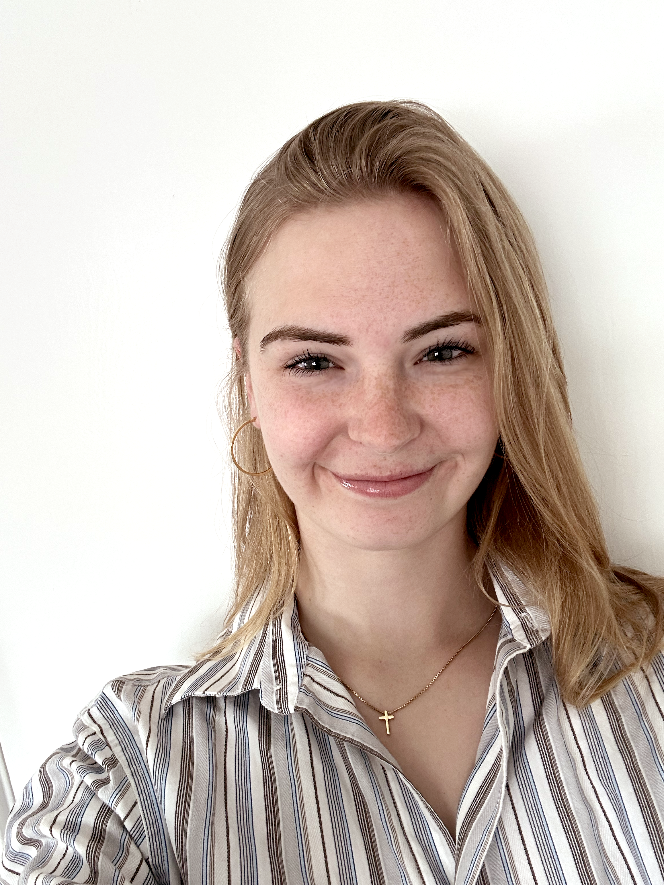 Woman in a striped button down shirt smiling