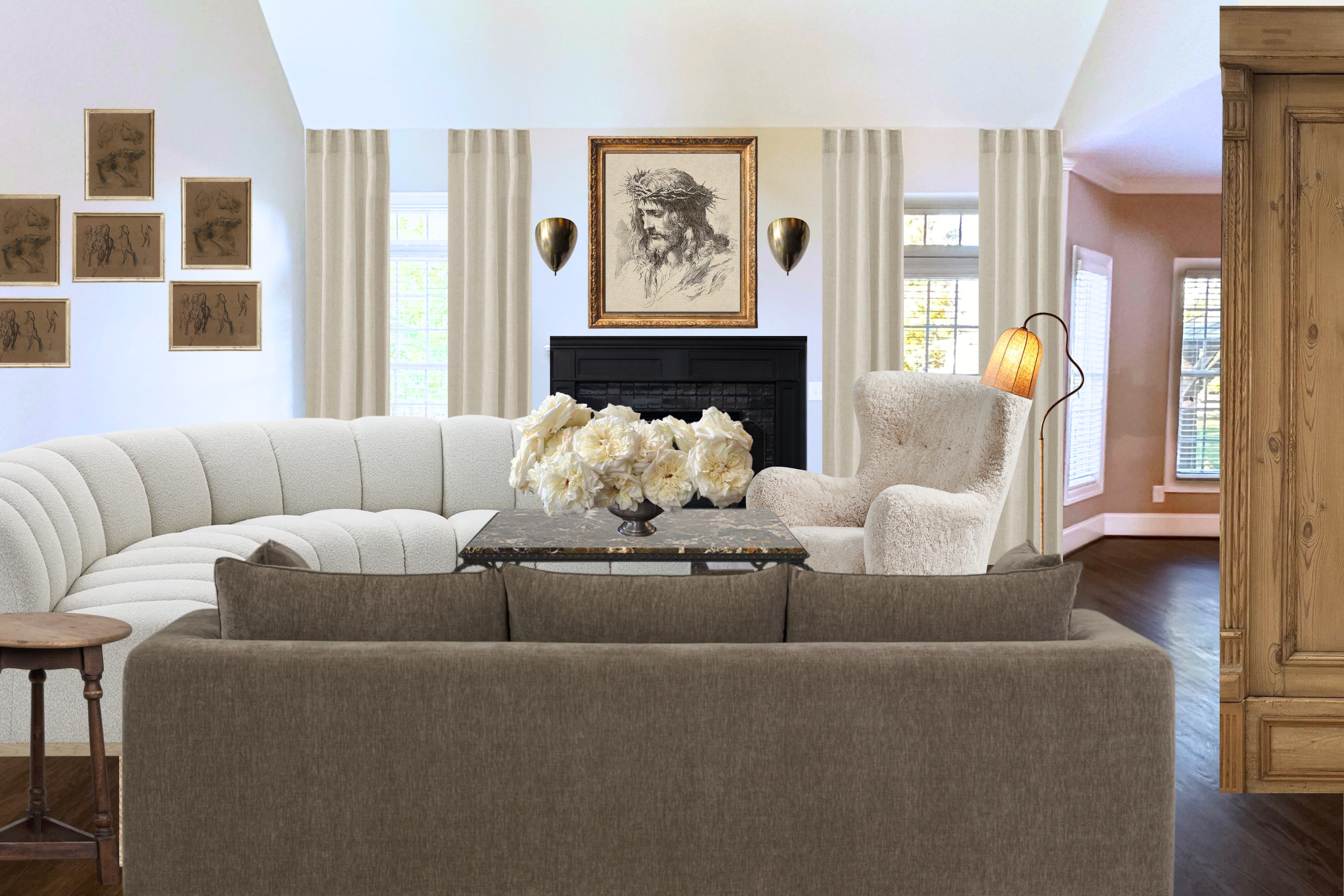 Living room with a white upholstered curved sofa, a brown side table, a beige armchair with a lamp, and a coffee table with a bouquet of white flowers. The room features a black fireplace, framed artwork of a crown of thorns, and several small sketches on the wall, with a window behind the curtains.