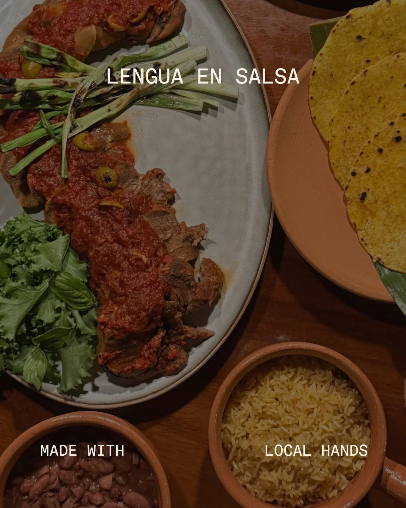 LENGUA EN SALSA 
En salsa de tomate con aceitunas, cebollitas asadas, hierbas y hojas frescas. Para compartir, servido con arroz cocinado en caldo de gallina, frijoles tiernos y tortillas caseras de ma&iacute;z. 

Beef tongue in tomato sauce with oli