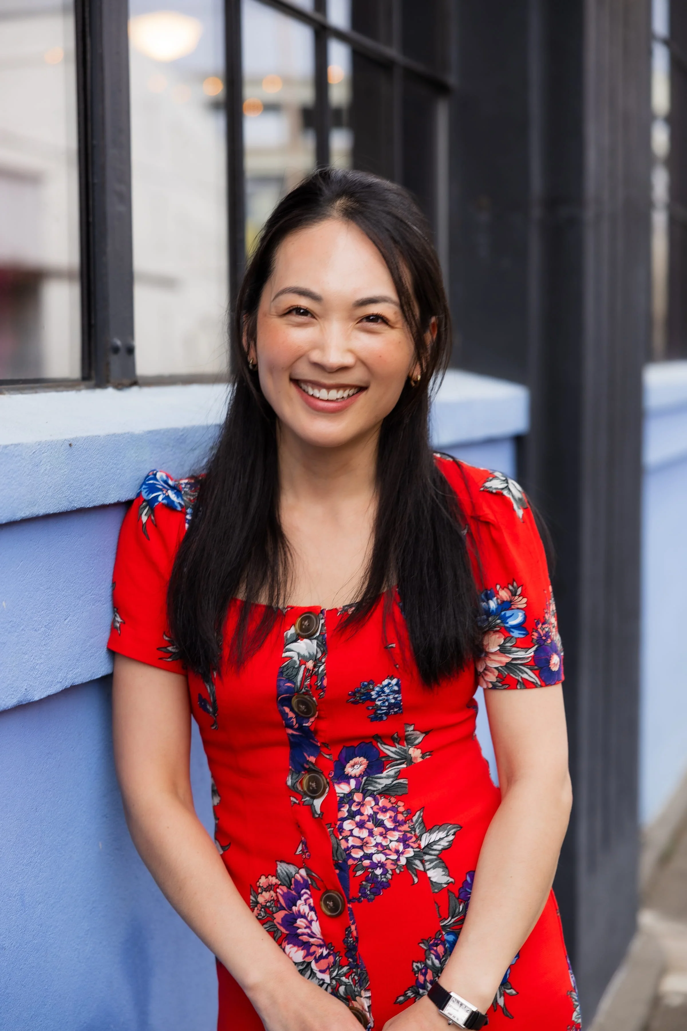 Veronica Kim of the Cause Catalyst smiling and standing in front of a background of green and bronze balloons.