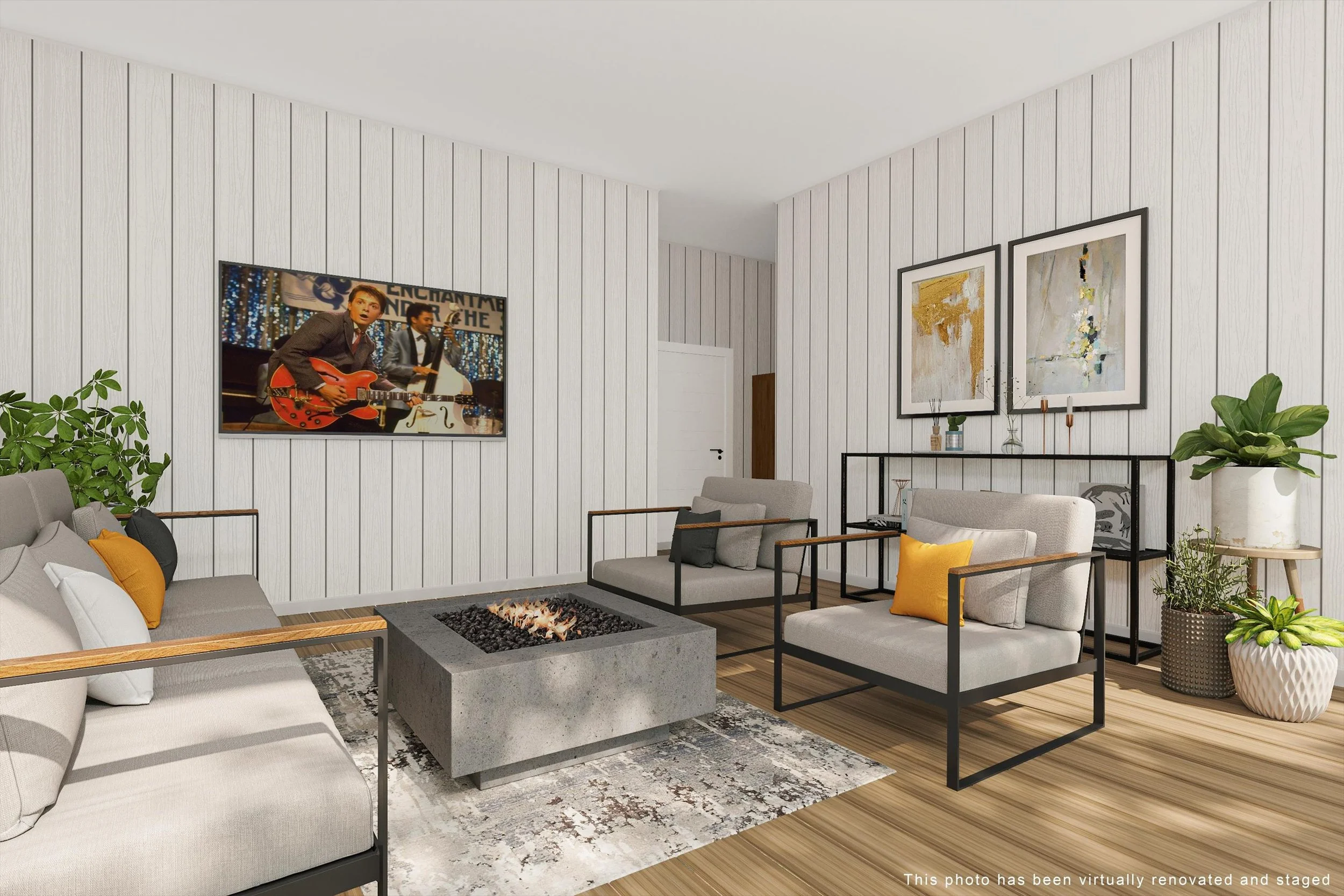 Modern living room with light-colored sofas, a rectangular concrete fireplace, framed abstract art, and potted plants, with a wall-mounted TV showing musicians.