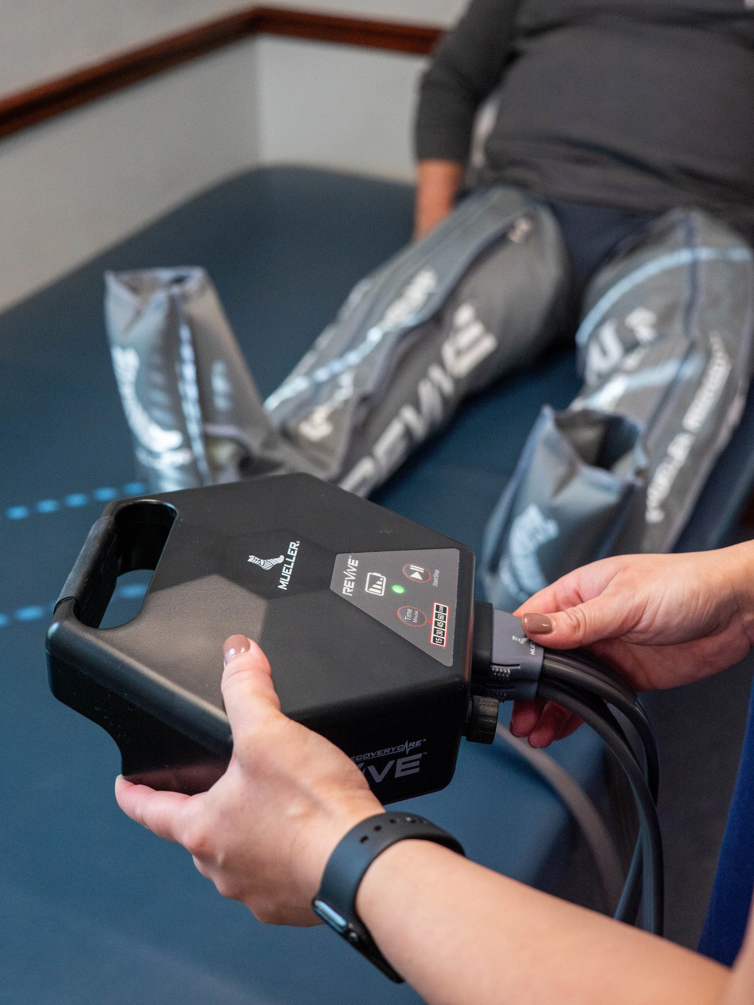 Person receiving an automated chest compression therapy from a medical device, with a patient lying on a bed.