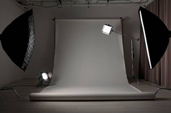 Photography studio with backdrop, studio lights, and softboxes.