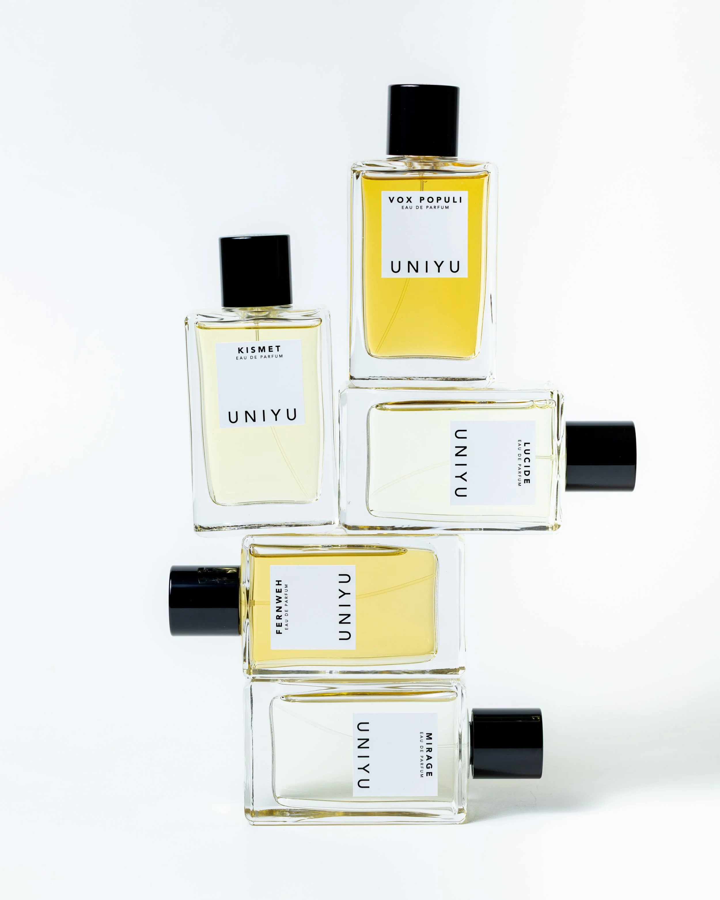 Five perfume bottles labeled UNYIU with different scent names arranged vertically with black caps on a white background. Photography by Lila Marvell www.lilamarvell.com.au