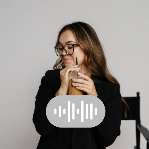 A woman with glasses and long hair drinking iced coffee through a straw.