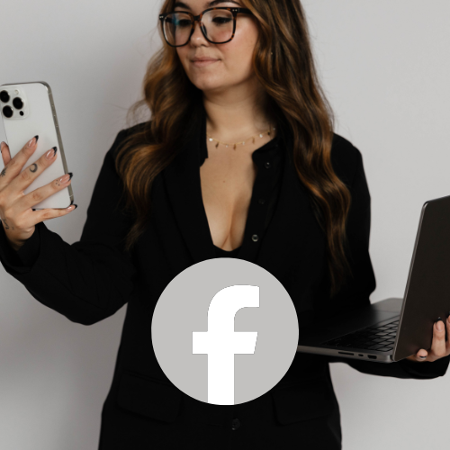 A woman with long brown hair and glasses, wearing a black blazer, holding a smartphone in one hand and a laptop in the other, standing against a plain white background.