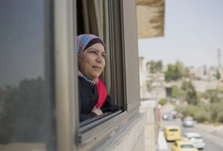 Kholoud looks out window.webp