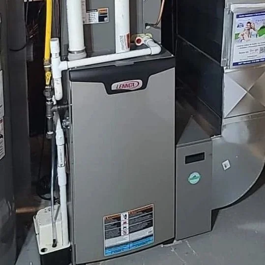 A Lennox HVAC furnace system installed next to a metal duct in a utility room.