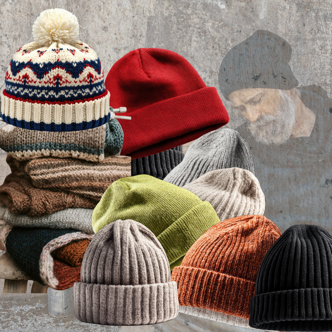Shows a homeless man leaning against a wall wearing a warm knitted beanie. In front of him are a variety of knitted beanies on a table.