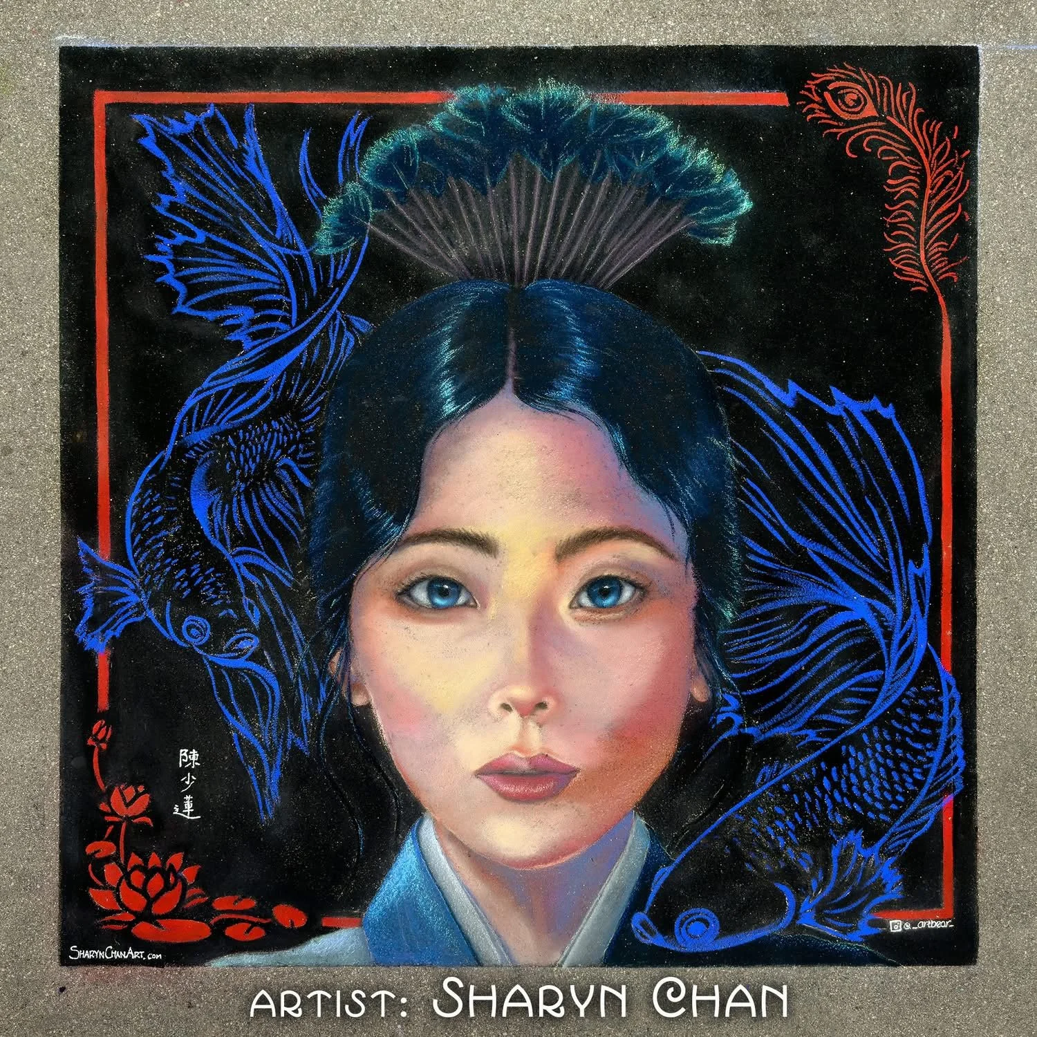 Colorful artwork of a young woman with blue eyes and black hair, framed by stylized blue fish and peacock feathers on a black background, with red accents and Chinese characters. Artist name: Sharyn Chan.