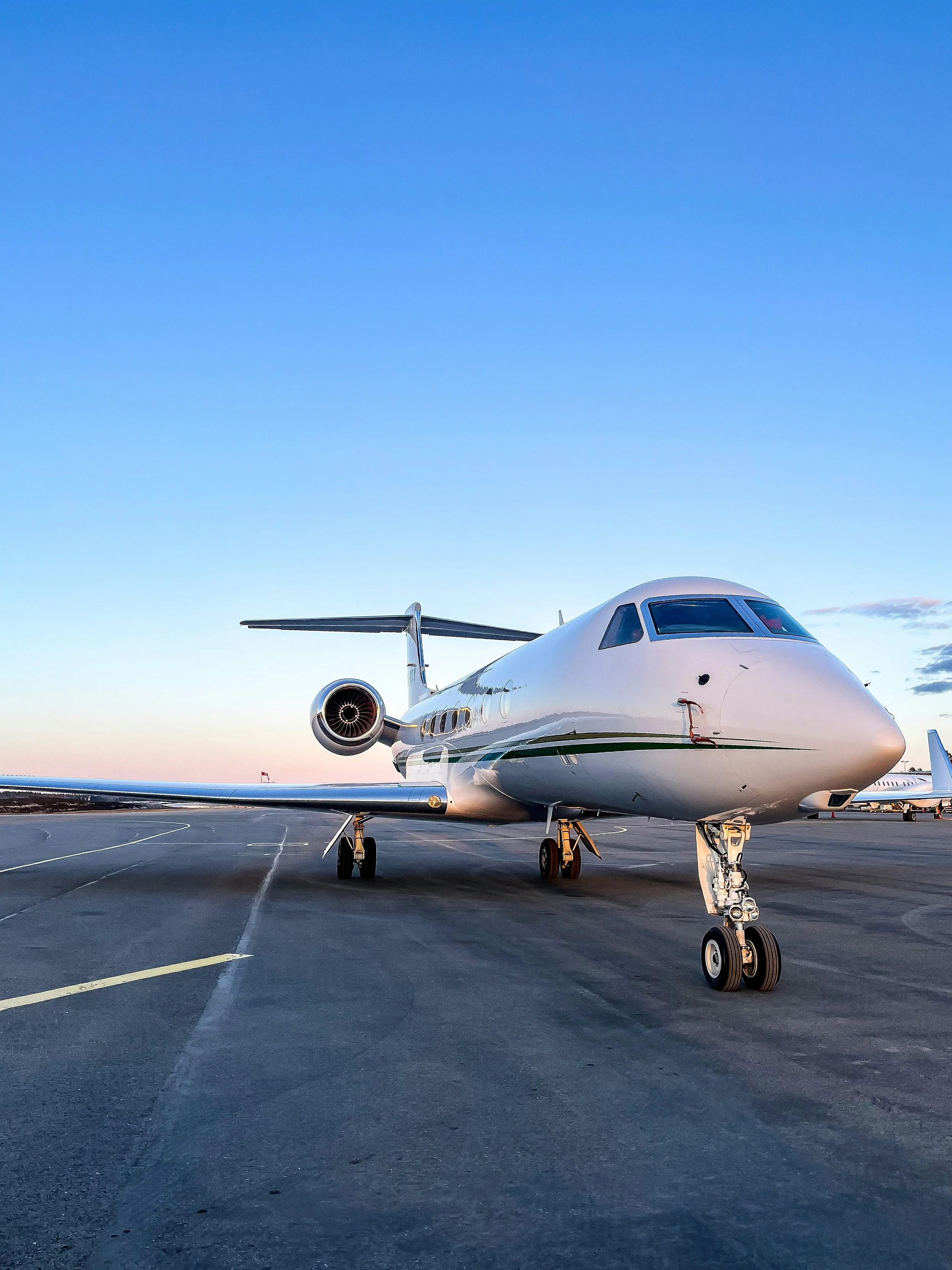 Private jet on an airport tarmac during sunset
