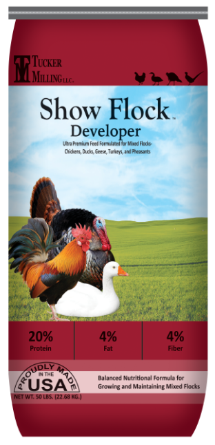 Tucker Milling show flock developer feed bag with illustrations of chickens, ducks, geese, turkeys, and pheasants, including a rooster, a duck, and a turkey, against a pastoral background
