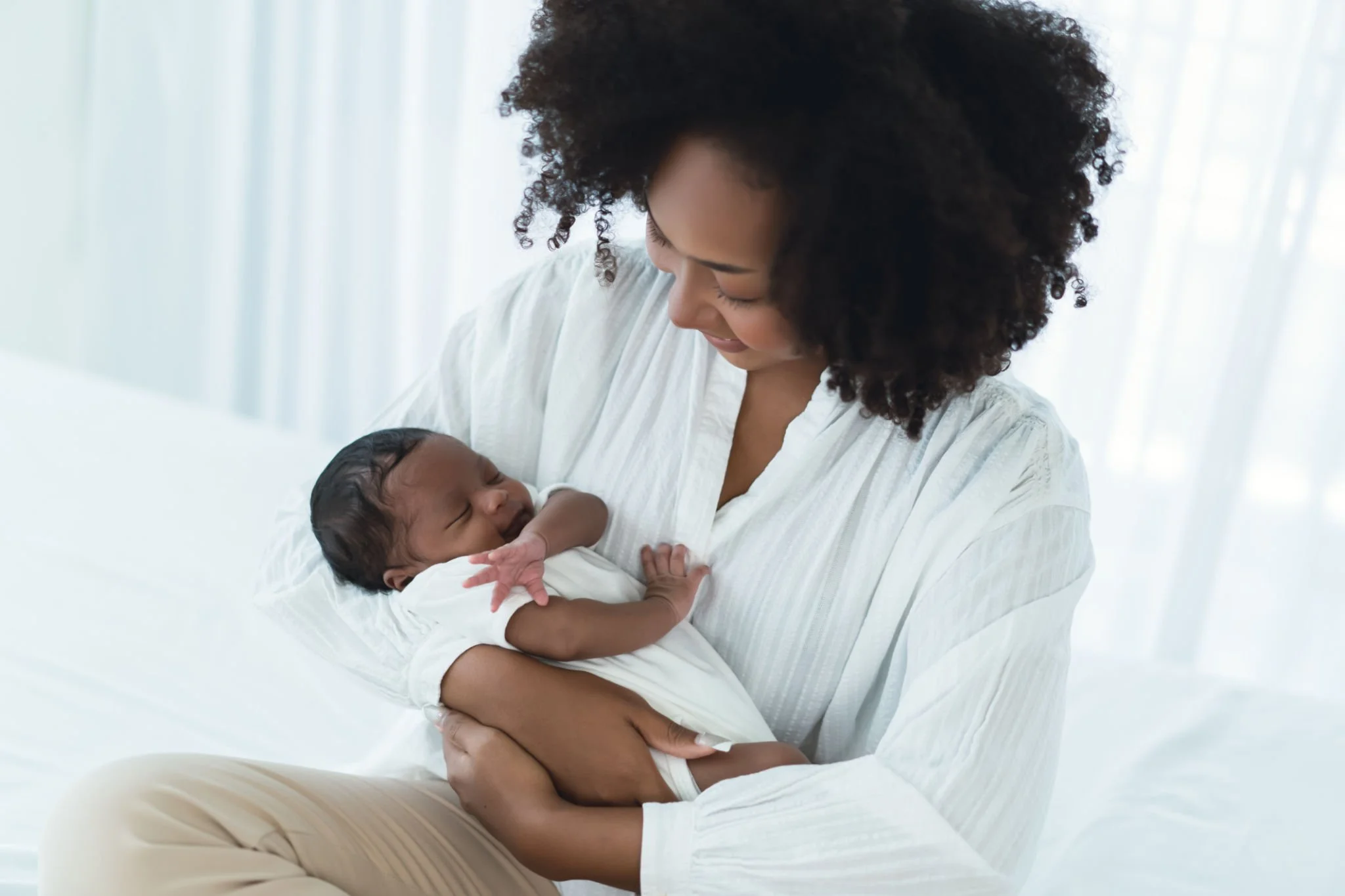 Mother holding her newborn during a postpartum mood and emotional wellness visit