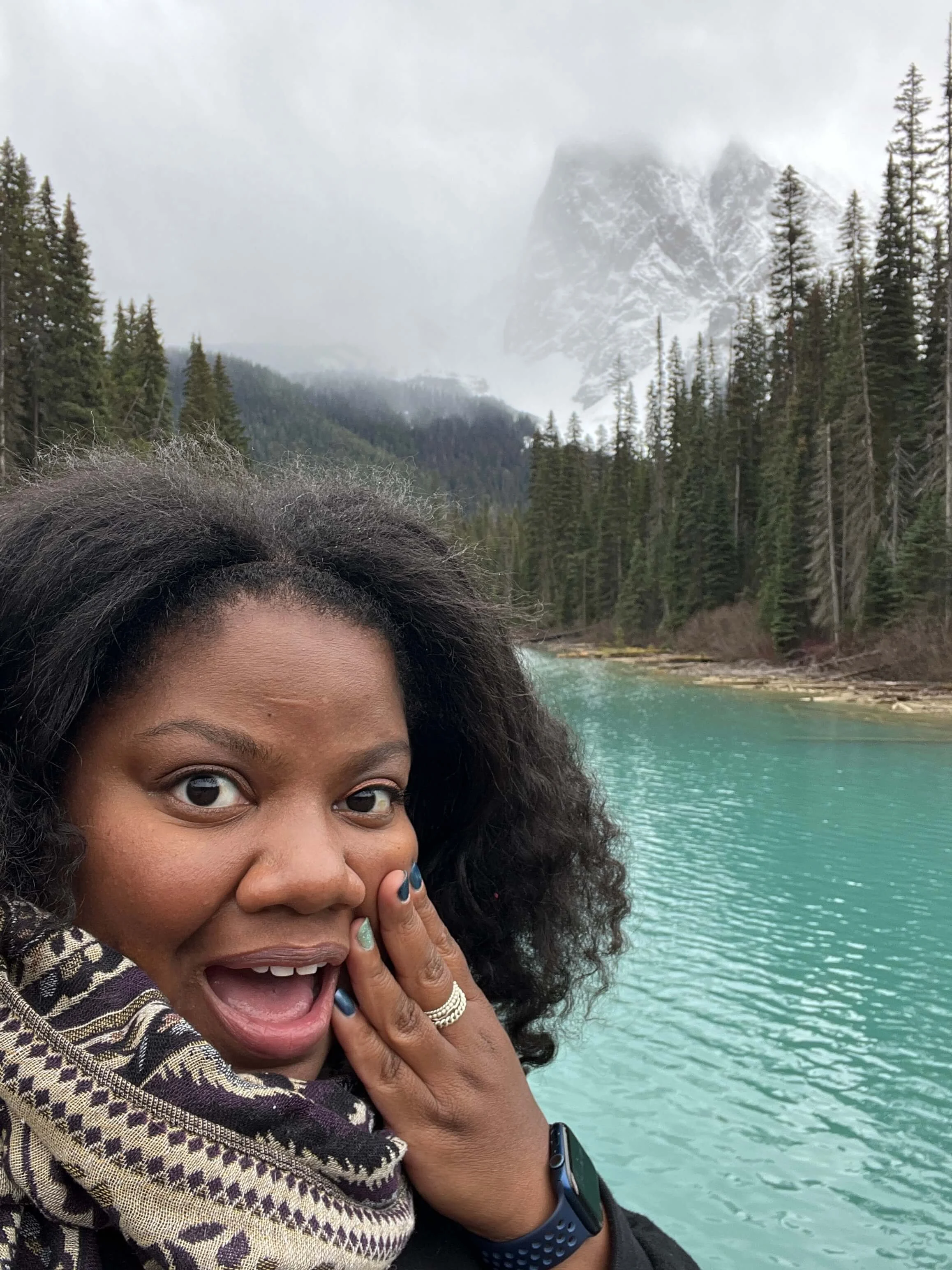 Lissette in a mountain region holding her face in surprise