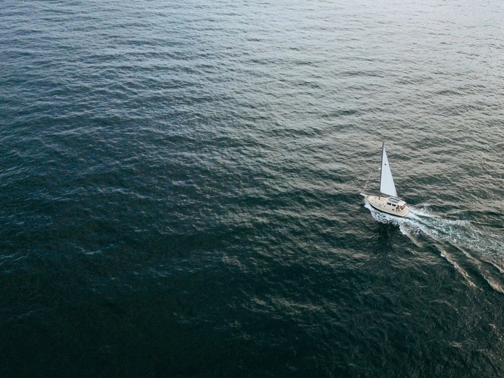 A sailboat sailing on the open ocean during daytime.