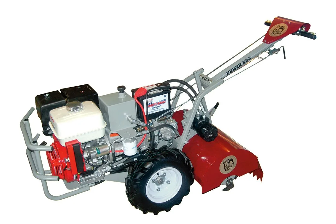 A red and gray power ground tiller with large tires and handlebars.
