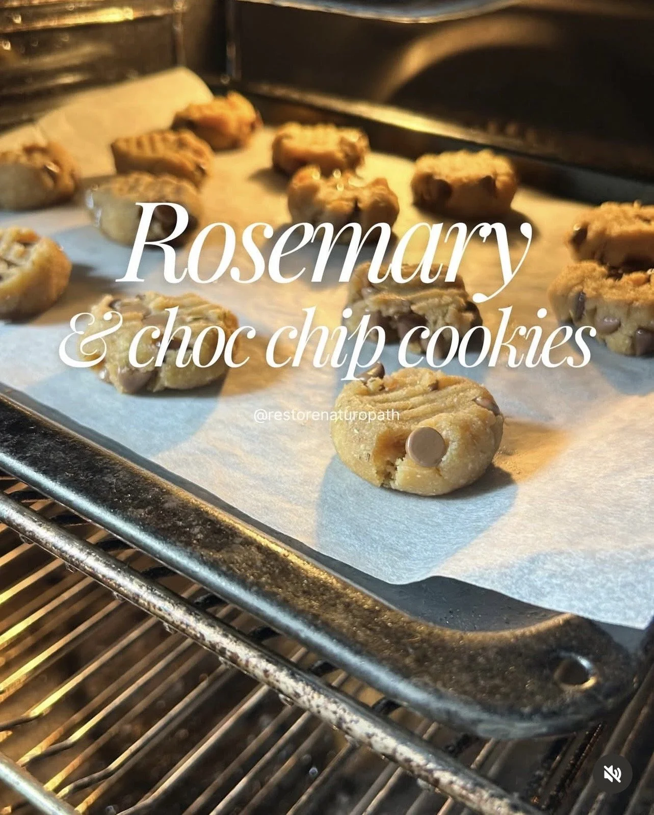 Cookies with chocolate chips and rosemary on a baking sheet in an oven