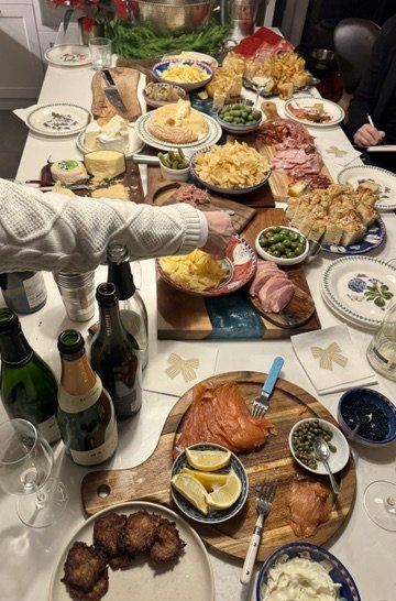 An in-use feasting table for a Champagne Masterclass event, featuring a latke, smoked salmon and caviar station.