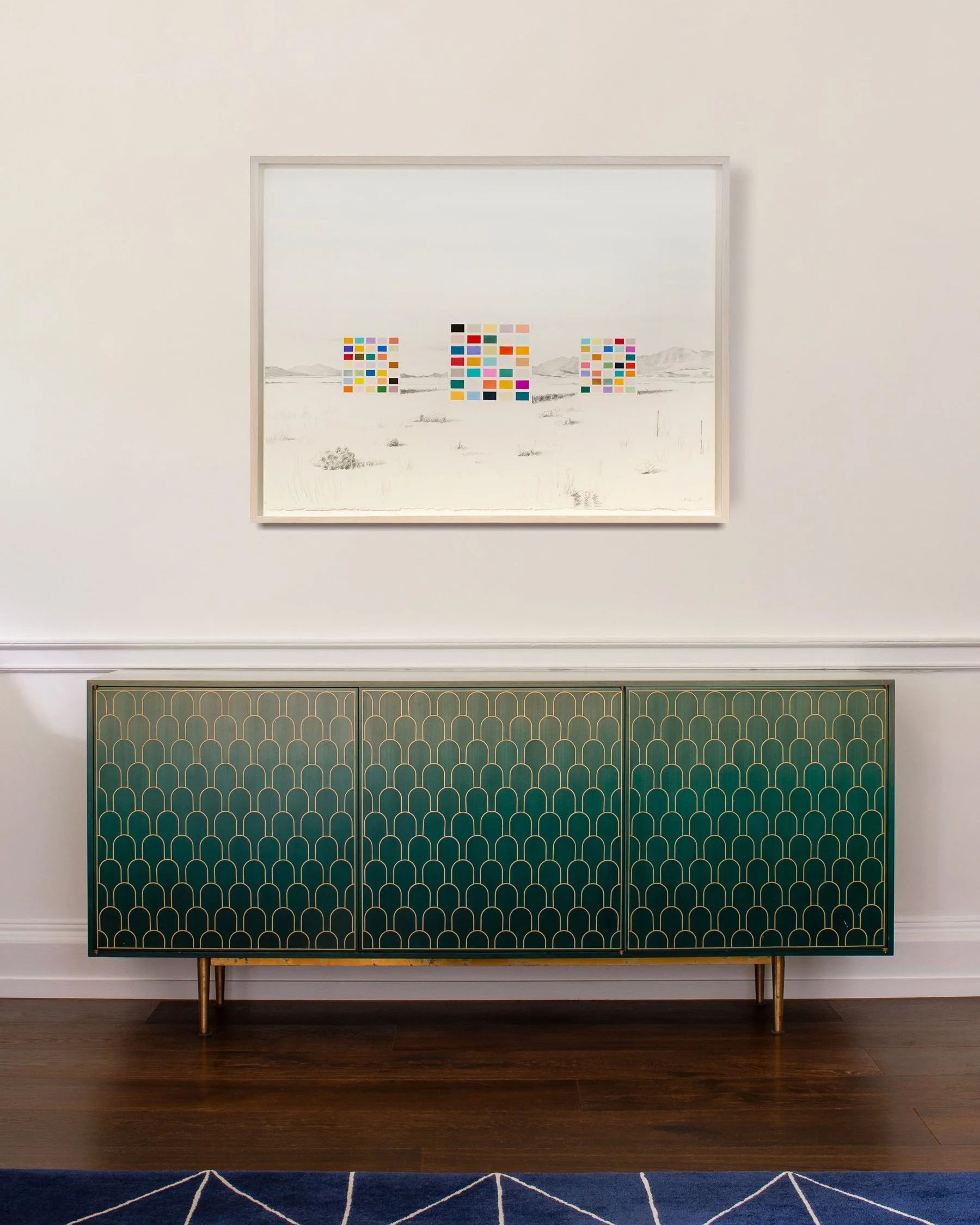 Original work by artist Marth Beaumont hanging above a modern side cabinet