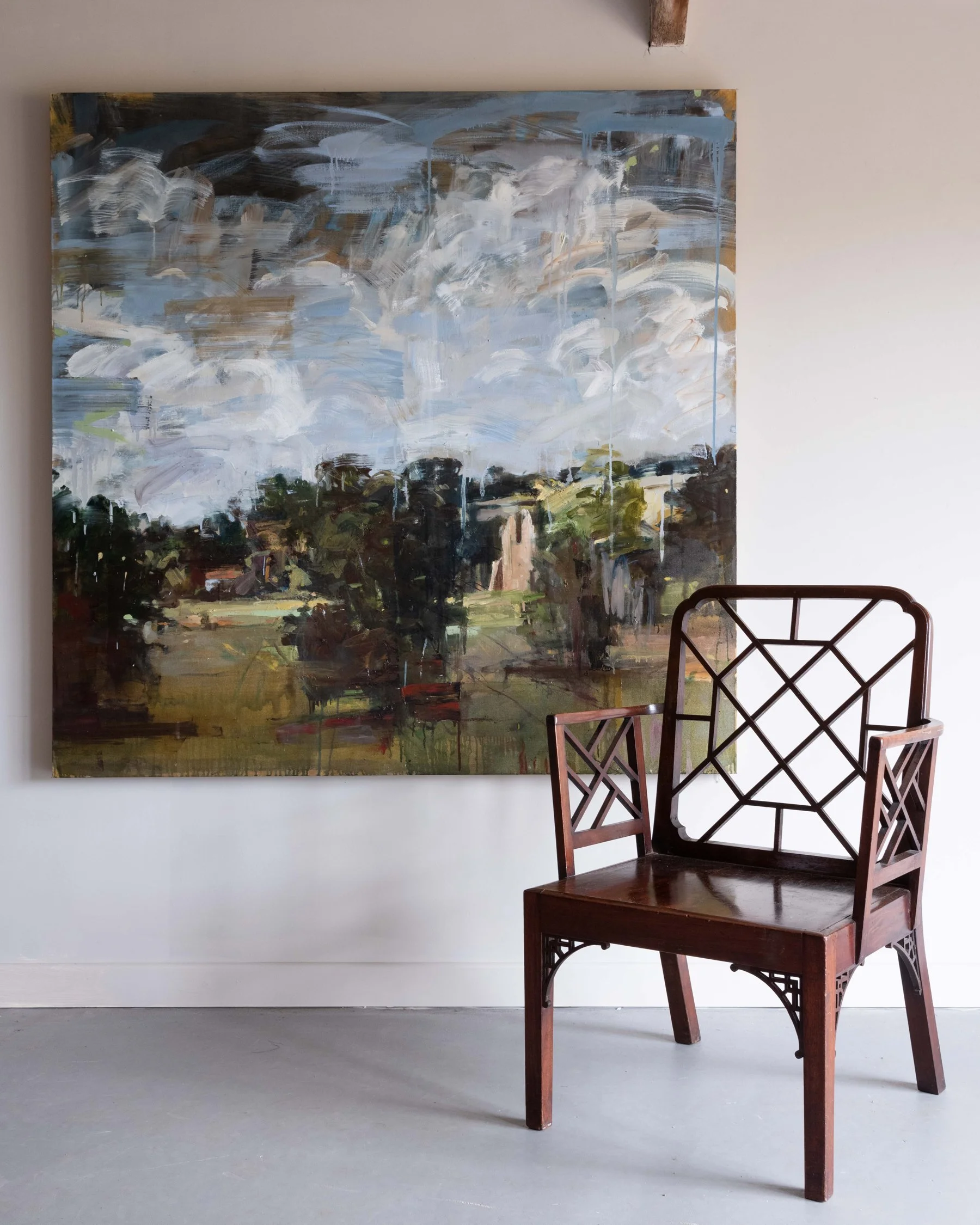 An original painting by artist Kate Giles hanging alongside an antique chair