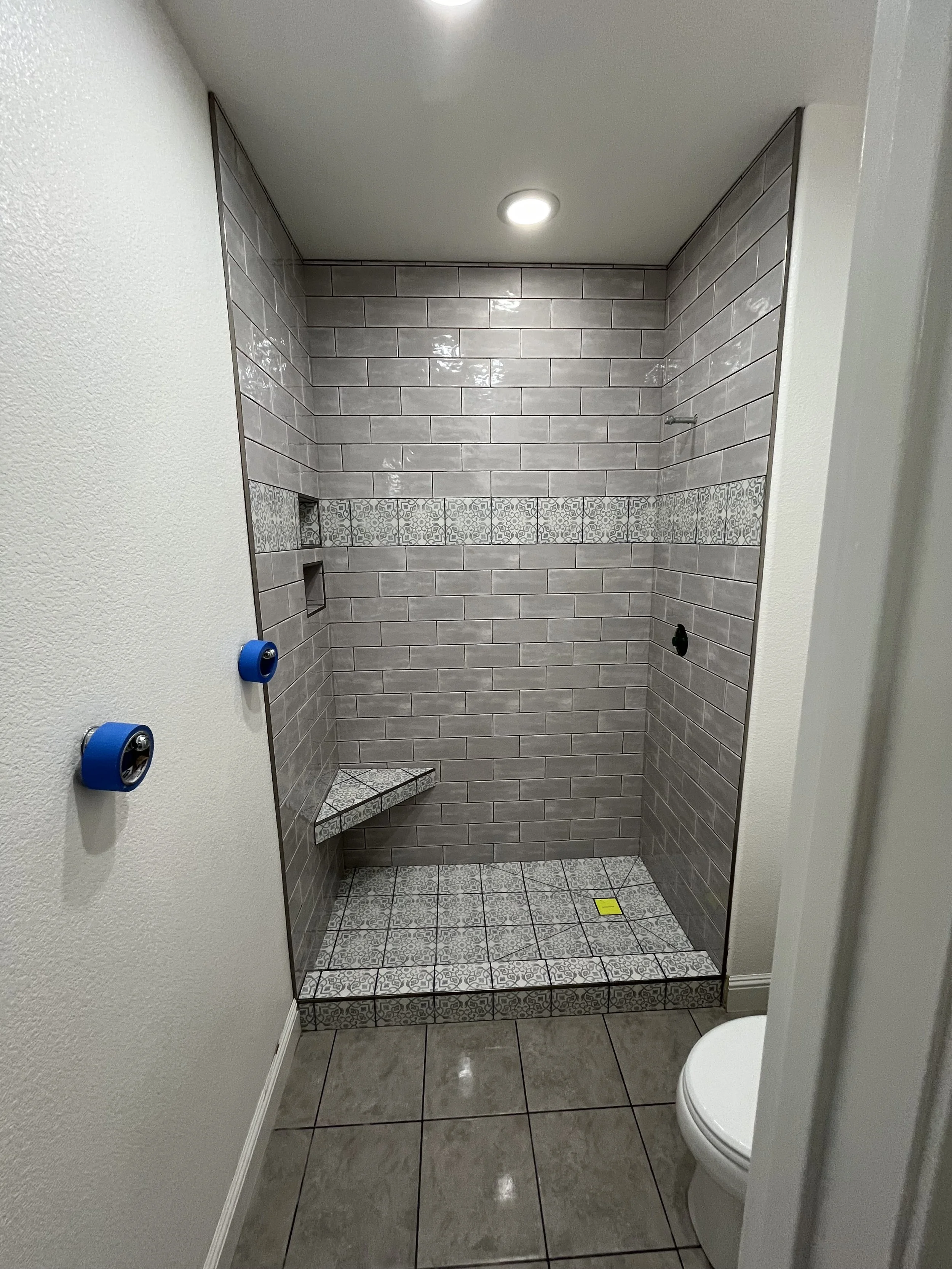 Jack and Jill bathroom renovation in Reno, NV: converted tub surround into a custom walk-in shower featuring a built-in niche, bench, and a custom large-format envelope-cut shower pan by Revive Tile Co