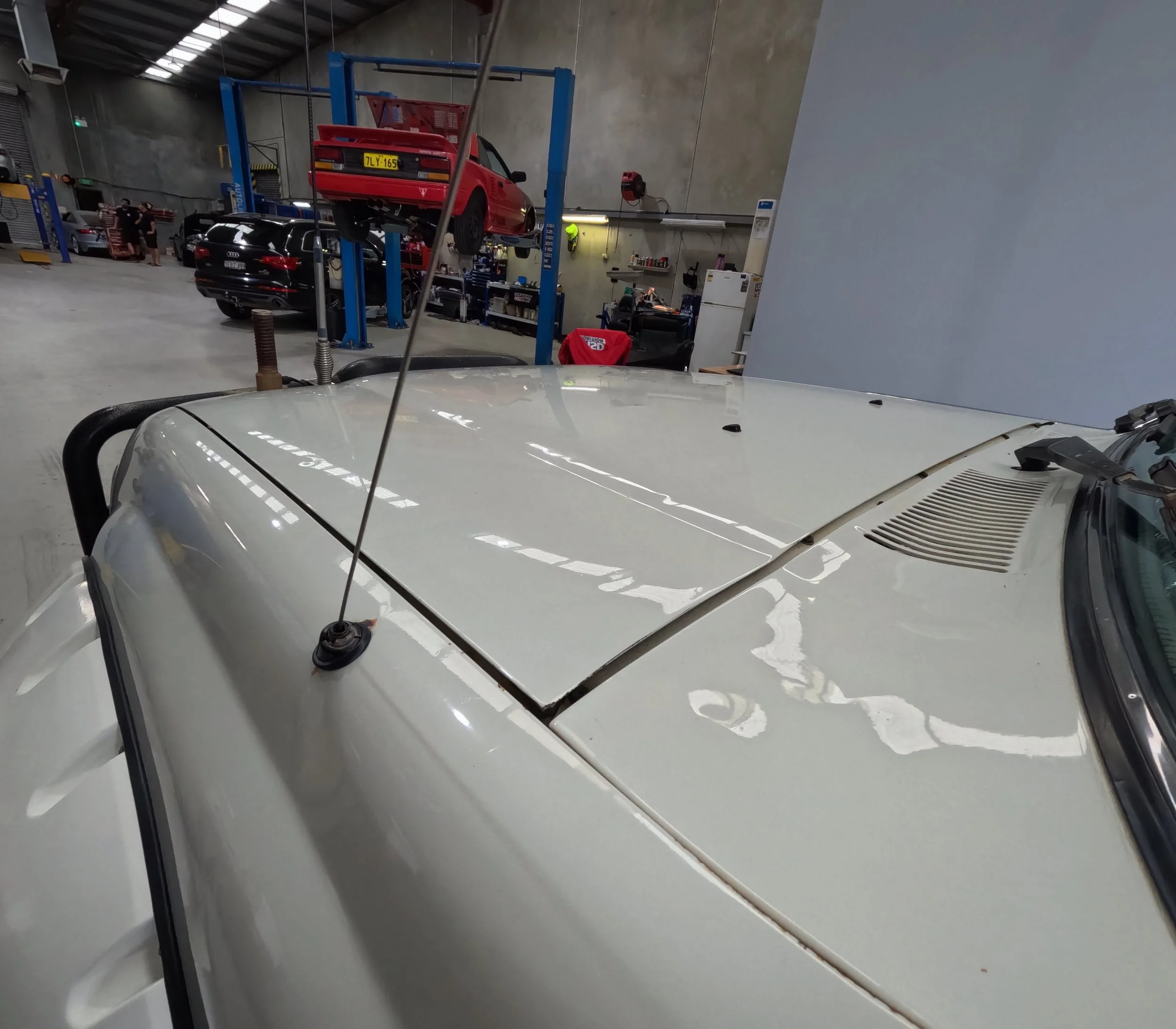 Paint correction and wax protection on a modified Toyota LandCruiser 80 Series in Perth. Professional gloss restoration on a white 4WD bonnet, essential for protecting off-road vehicle paint.