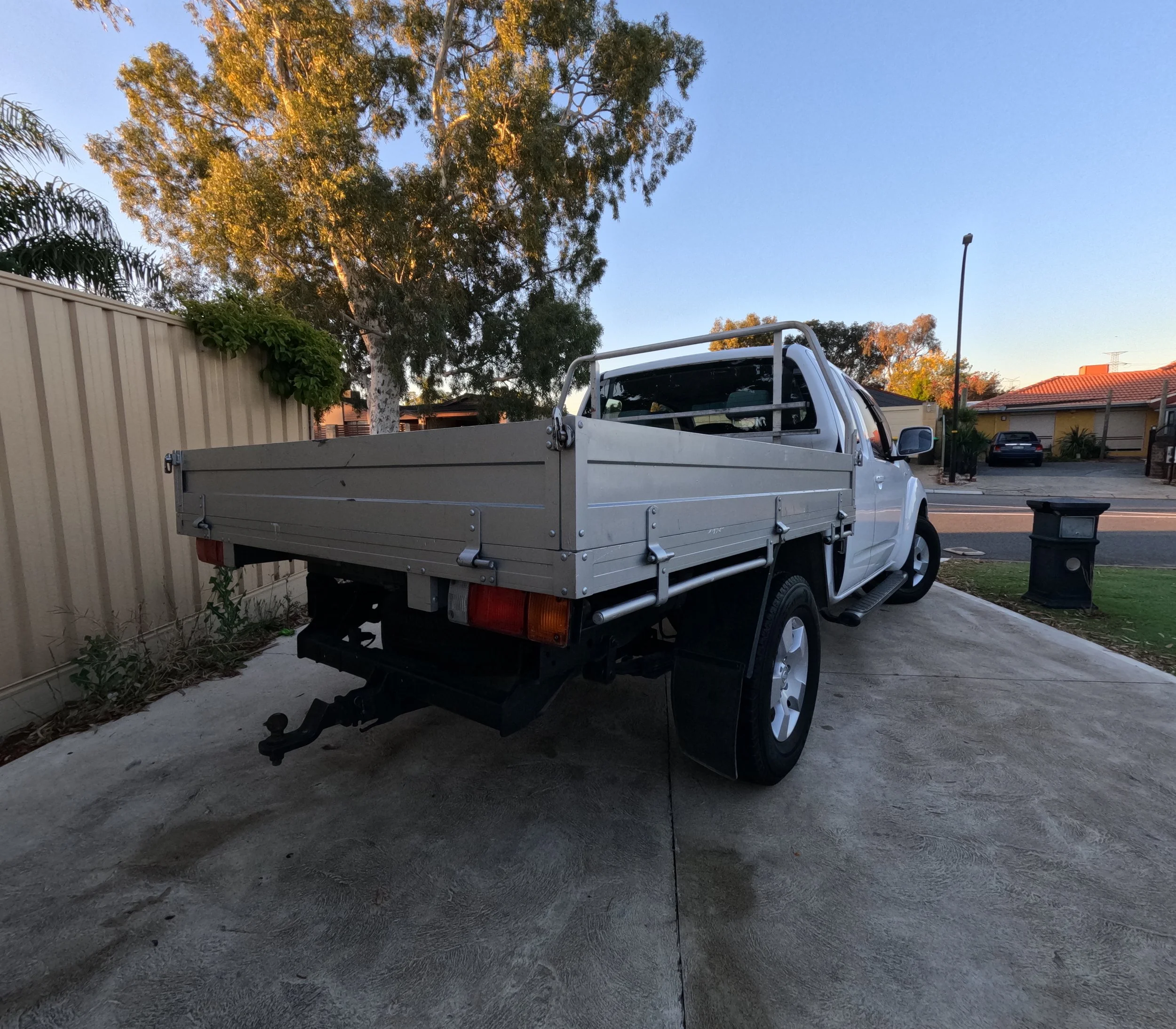 Professional vinyl business sign removal on a white Nissan Navara D40 in Perth. Pre-sale vehicle preparation including decal removal and exterior detailing for a clean finish.