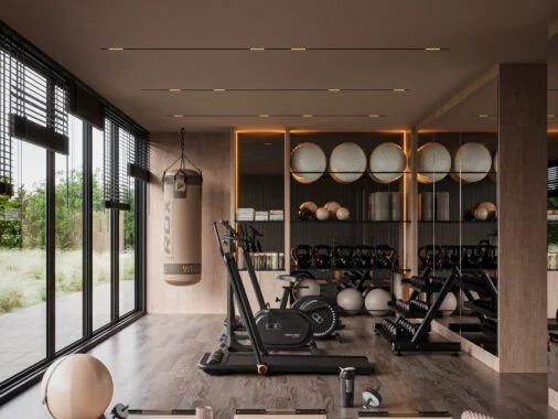 Modern gym with treadmill, elliptical, and weight benches in front of a wall of mirrors and shelves with exercise balls.