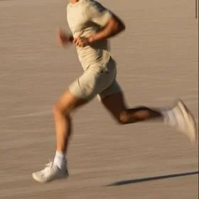 Person running on a dirt or gravel surface