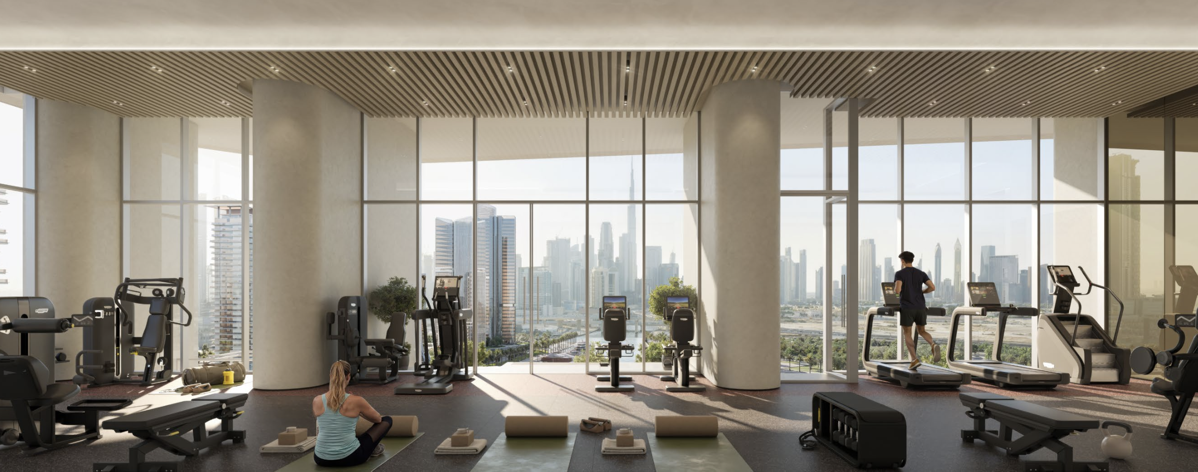 Modern gym with exercise machines, a woman doing yoga on a mat, and a man running on a treadmill, with large windows overlooking a city skyline.