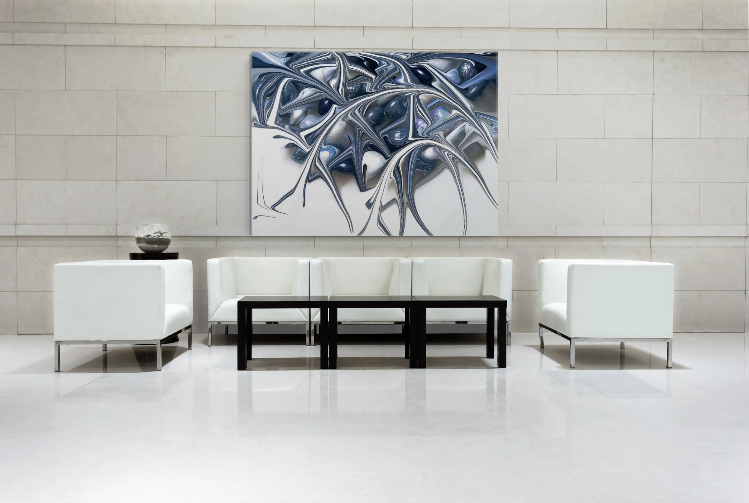 Modern interior space with white chairs arranged around a black table, a glass bowl with decorative stones on a side table, and an abstract painting with swirling black, gray, and white patterns on a beige tiled wall.