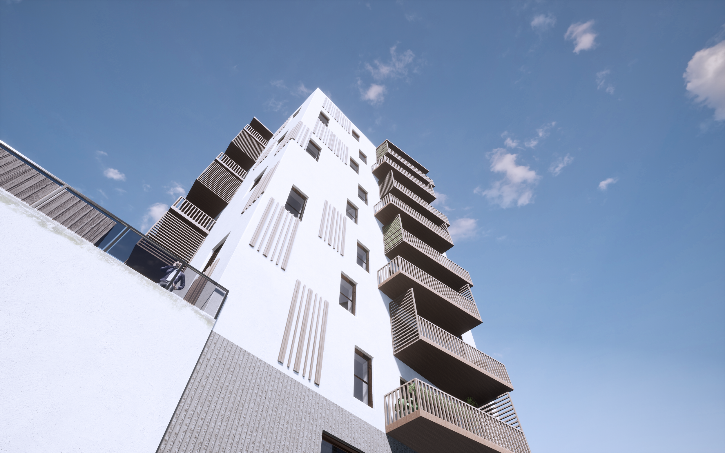 Fleretagers boligbygning med udendørs balkon mod blå himmel.