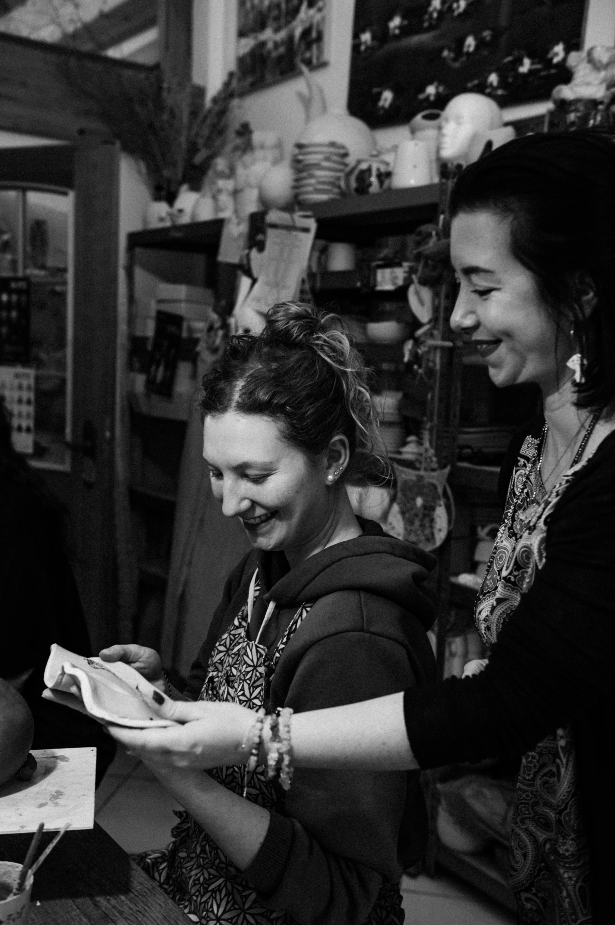 Two women smiling and looking at inspiration for a ceramic workshop