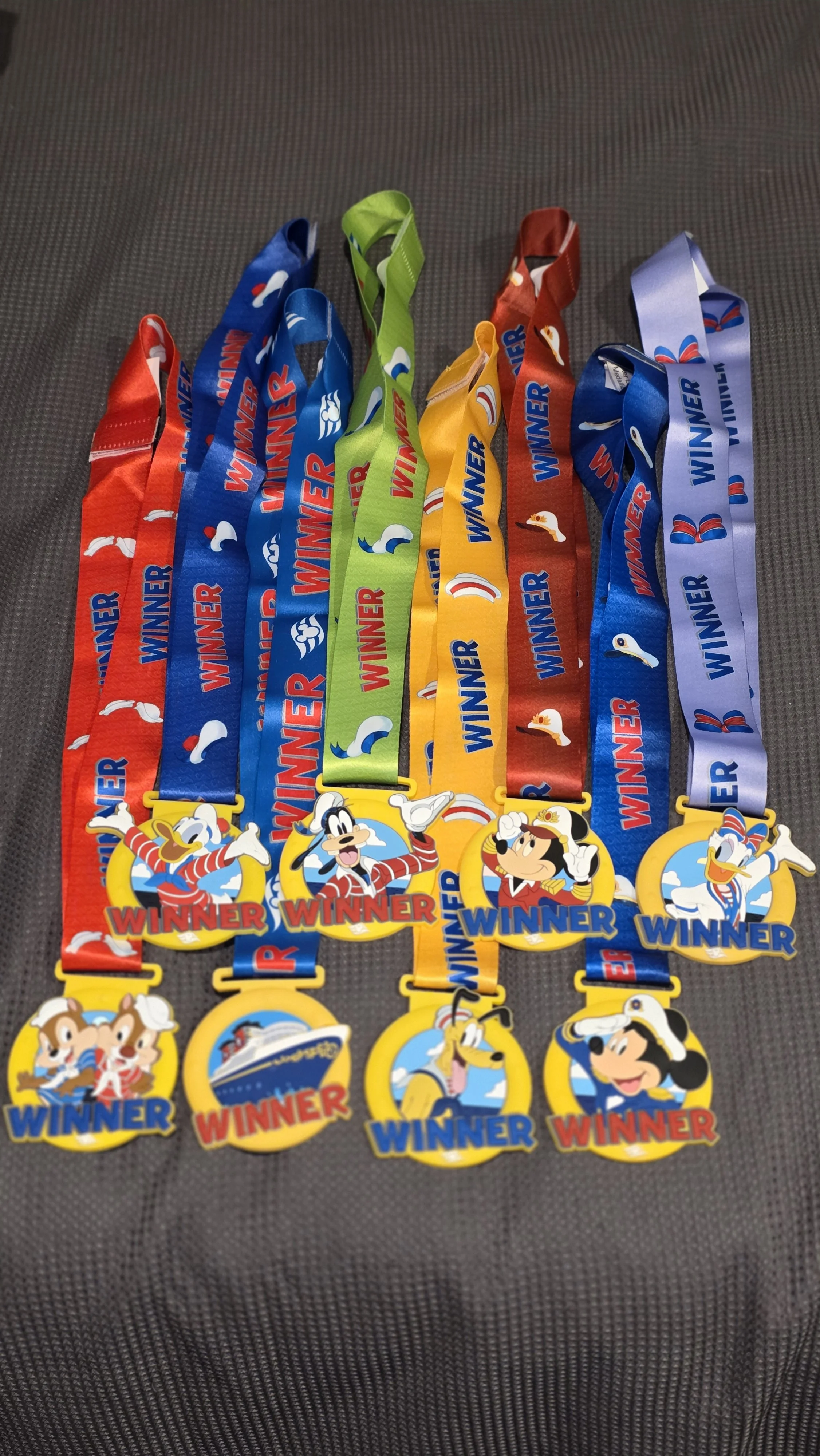Radio medals with Disney characters Mickey Mouse, Donald Duck, Goofy, and friends, labeled as winners.