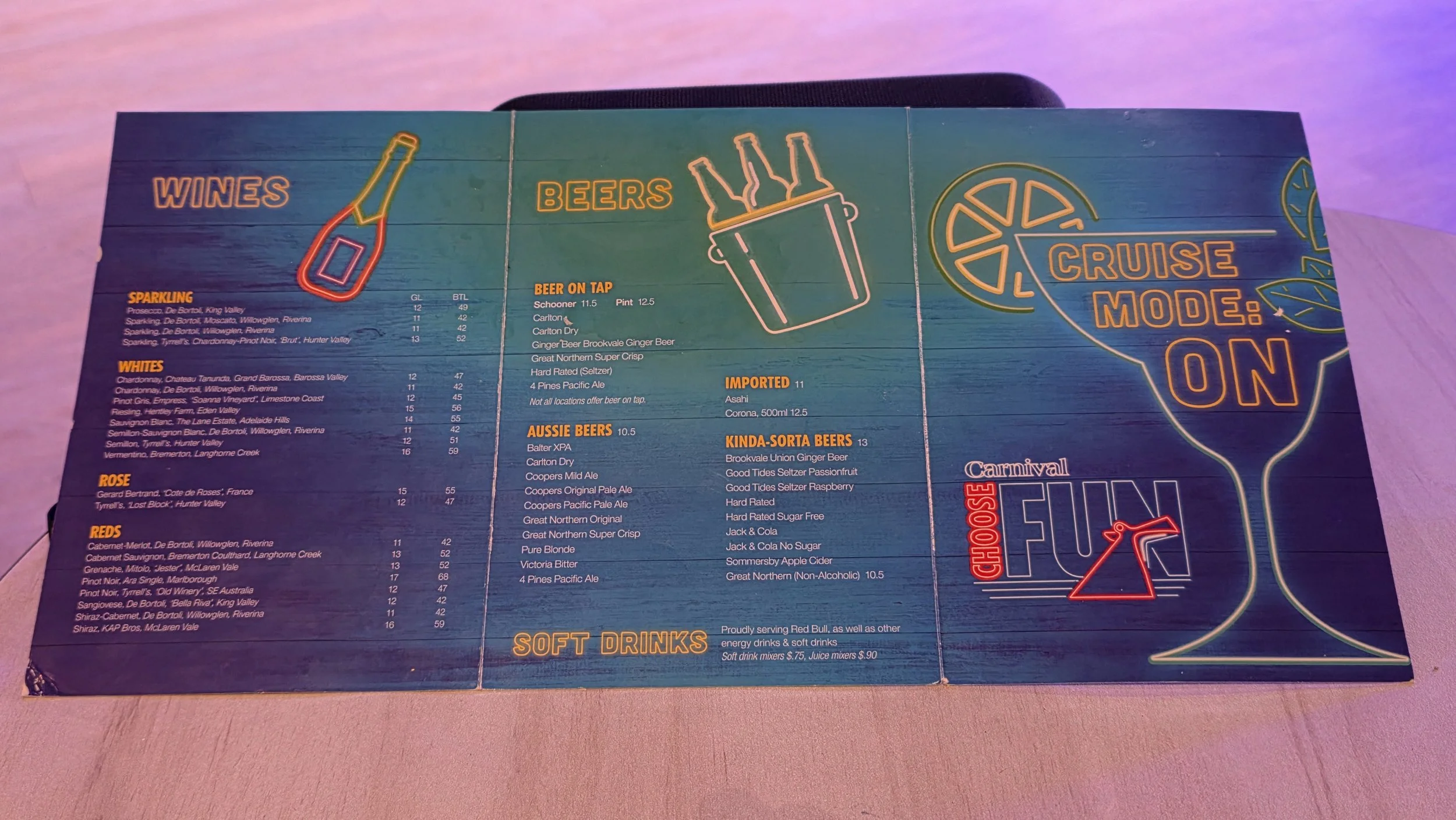 Bar menu with neon-style graphics of wine bottles, beer bottles, and citrus slices, featuring sections for wines, beers, cruise mode, and soft drinks.