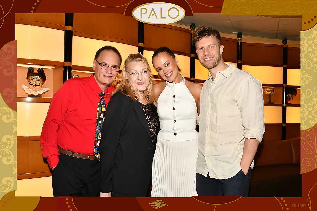 Four people standing together and smiling in a restaurant with a decorative background and a sign that reads 'PALO'