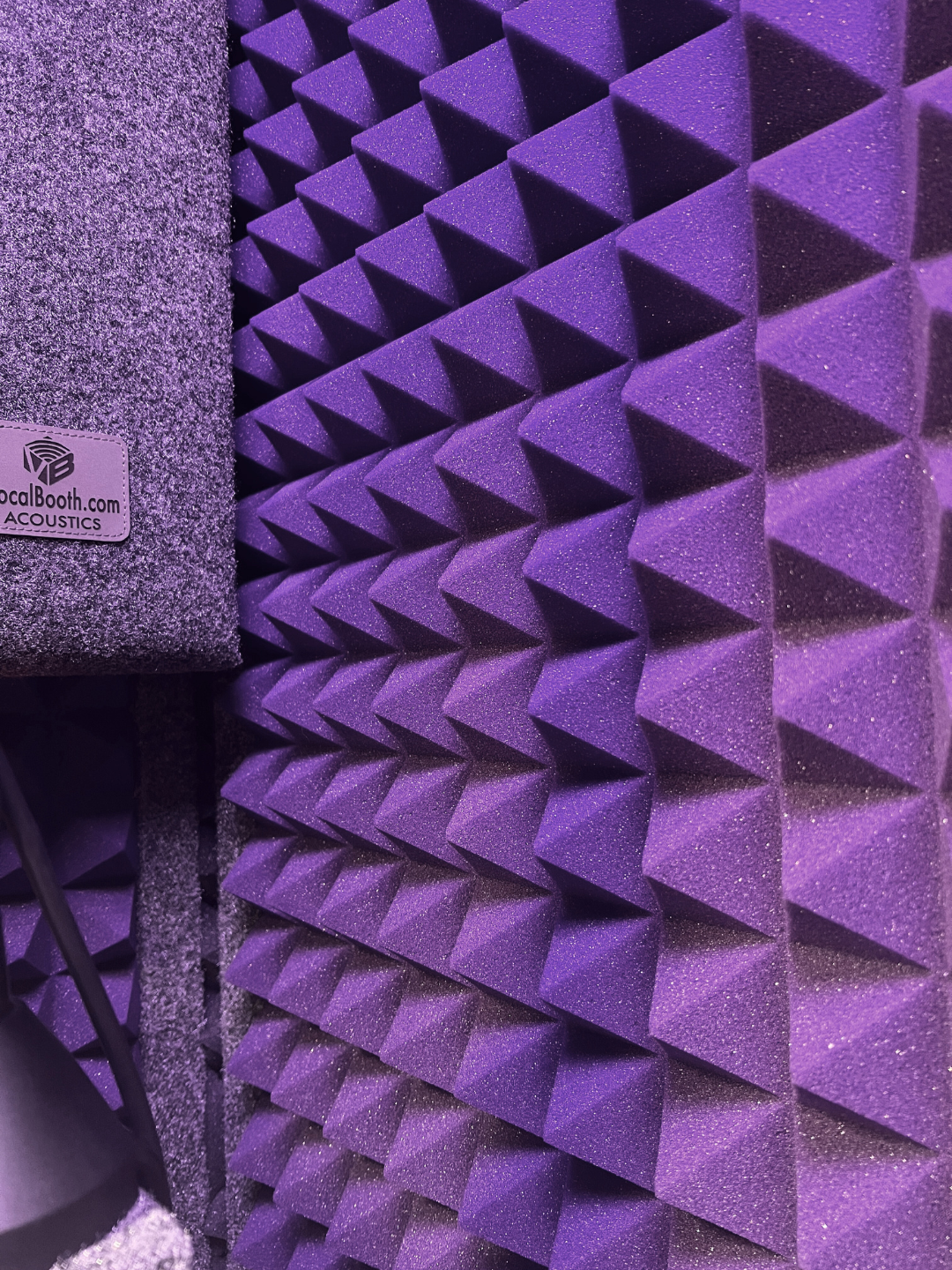 Purple acoustic foam panels with pyramid-shaped soundproofing pattern and a small grey fabric acoustic panel labeled 'LocalBooth.com ACOUSTICS' in the corner.